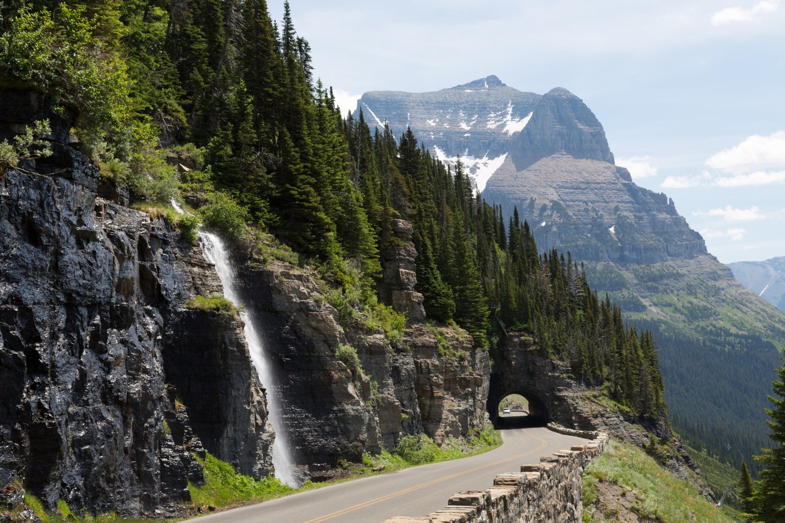 Waterfall and forest along road in Glacier National Park, British Columbia.