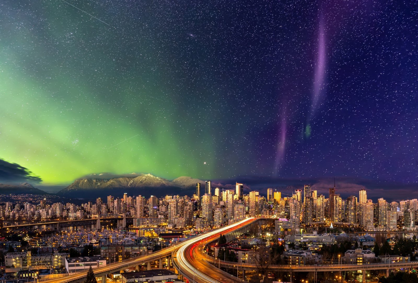 The aurora borealis illuminating the night sky over the Vancouver skyline.