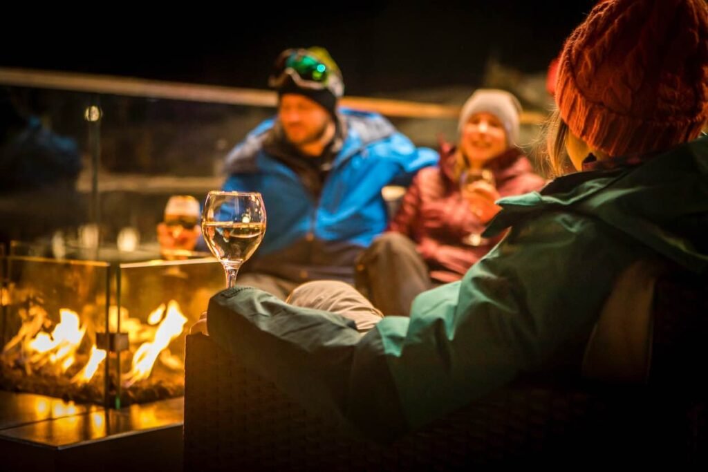 Guests enjoying a cozy fireside lounge in Whistler after skiing, part of a BC winter foodie road trip experience.