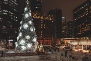Christmas in Vancouver - Giant illuminated Christmas tree in downtown Vancouver surrounded by urban buildings and snow-covered plaza